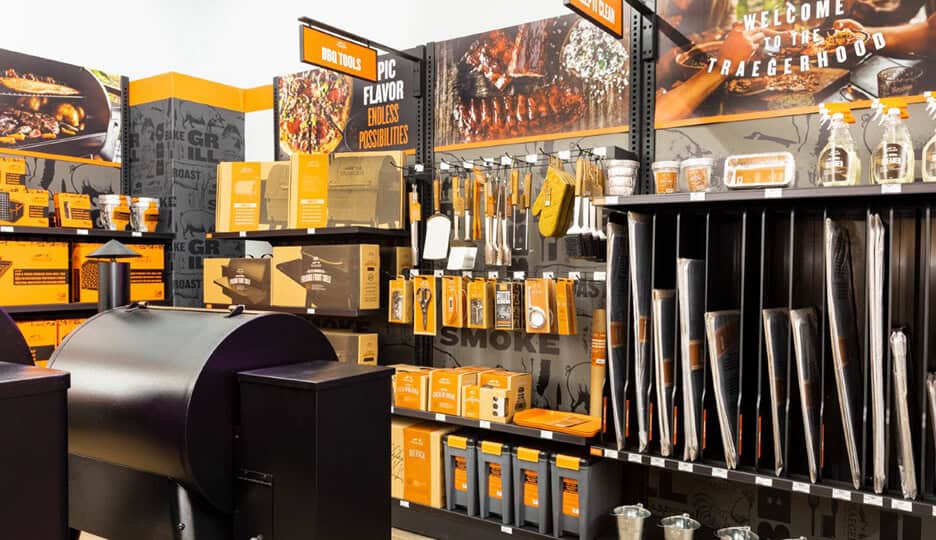 Traeger grill accessory wall with tools, liners, and cleaning supplies in a retail store setup.