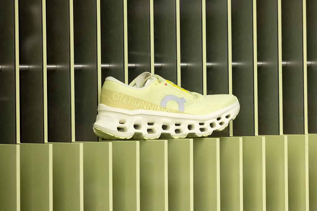 Close-up of a yellow On Running sneaker with Pantone-matched display background, highlighting brand consistency and color accuracy for retail presentation.